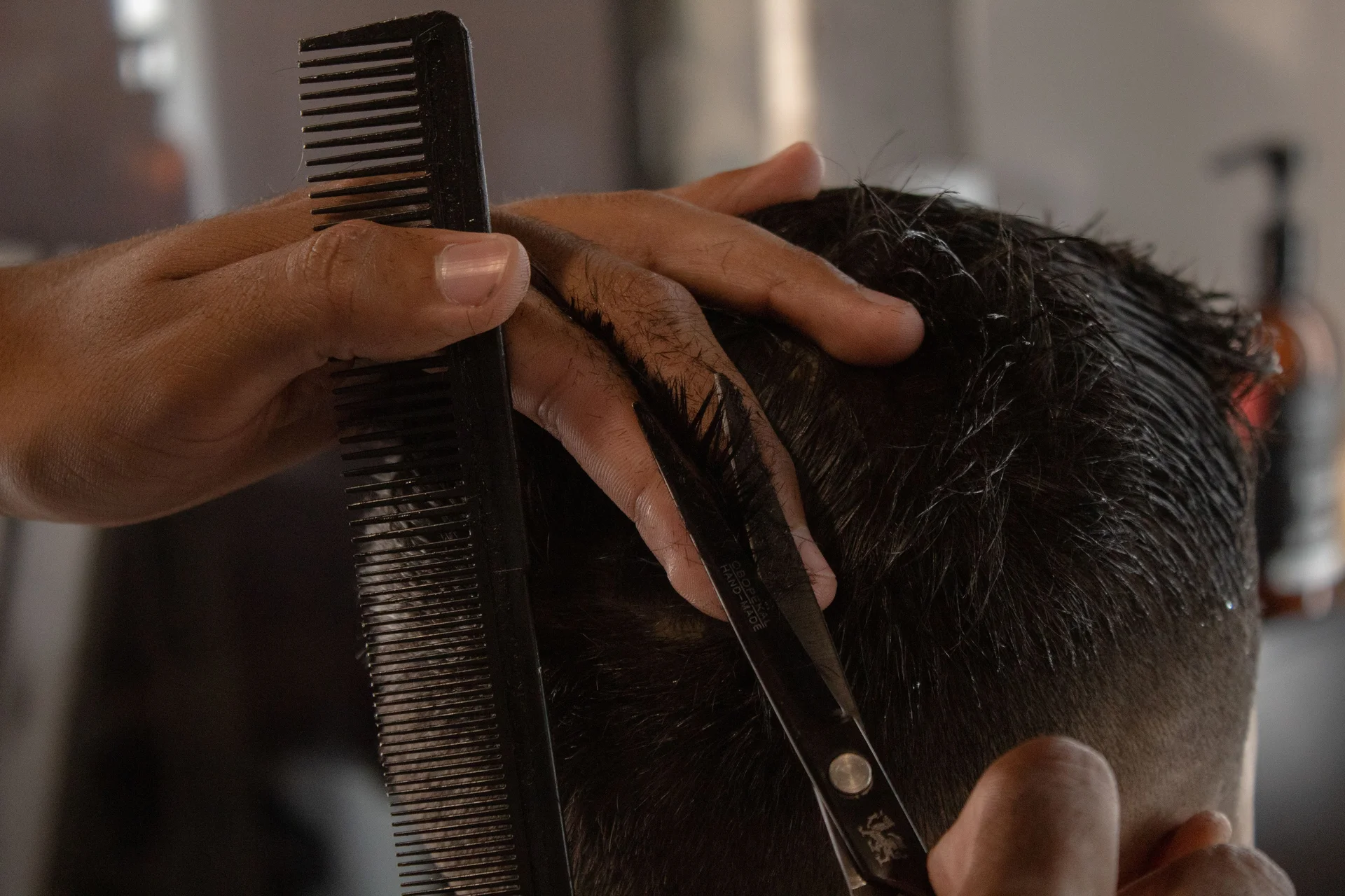 A men's haircut with scissors and comb